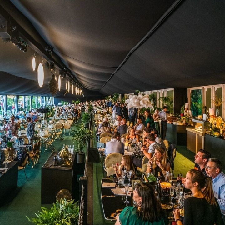 Vue sur des tables et des groupes de personnes autour