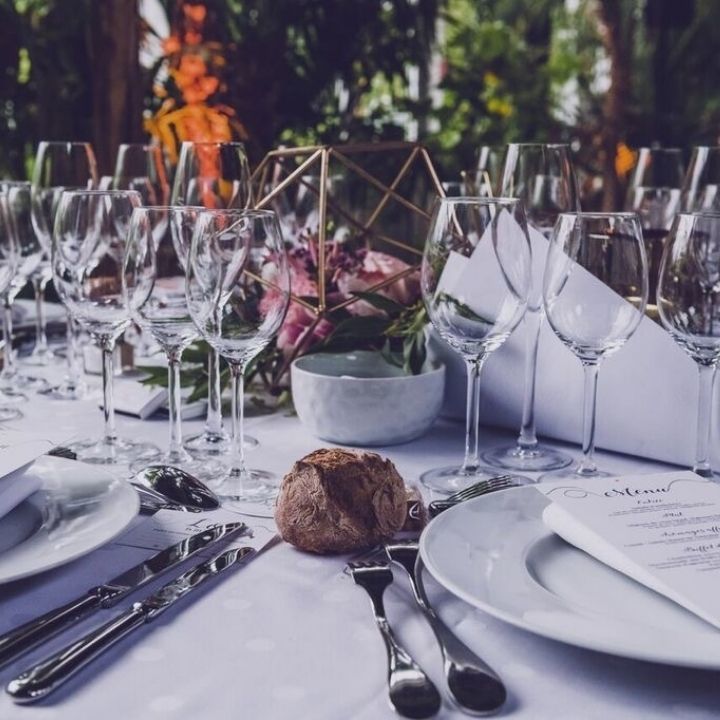 Verre de vin assiettes et couverts sur une table blanche