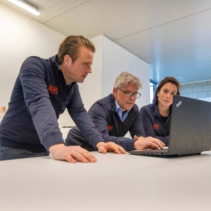 Trois personnes regardent un ordinateur